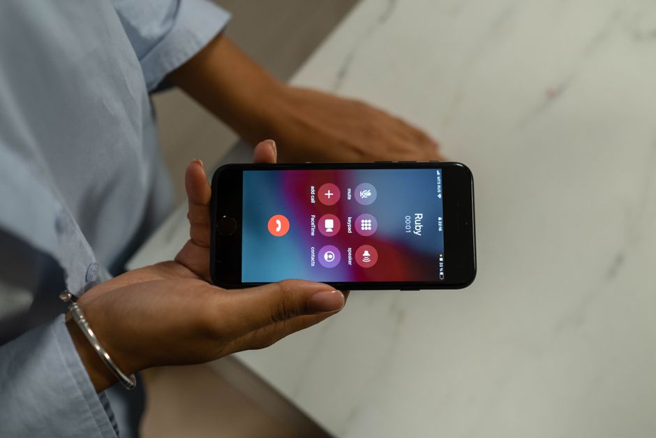 A hand holding a phone showing an incoming call