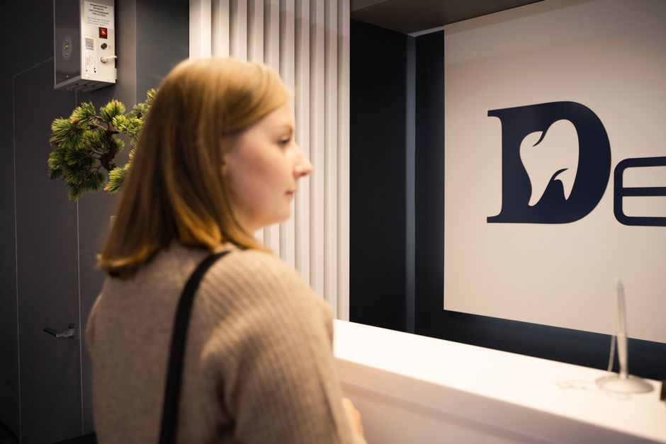 A patient waiting at a dental practice reception desk